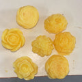 Sunrise yellow handcrafted soap roses, set of seven, on a cream surface